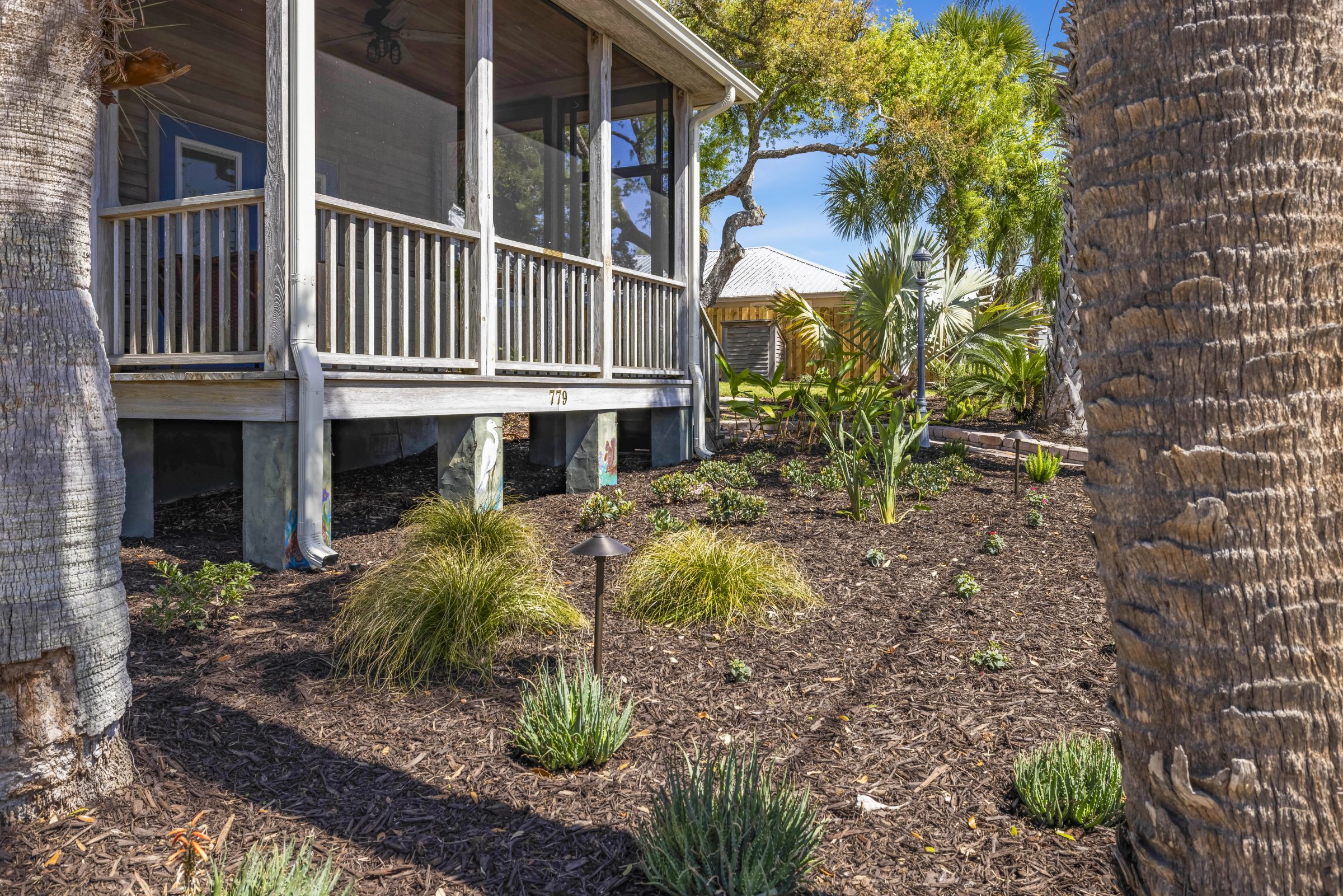Screened porch beside a landscaped tropical garden
