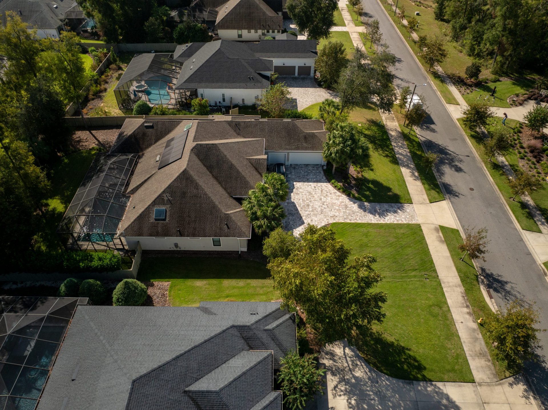 Aerial view of suburban homes with screened pools