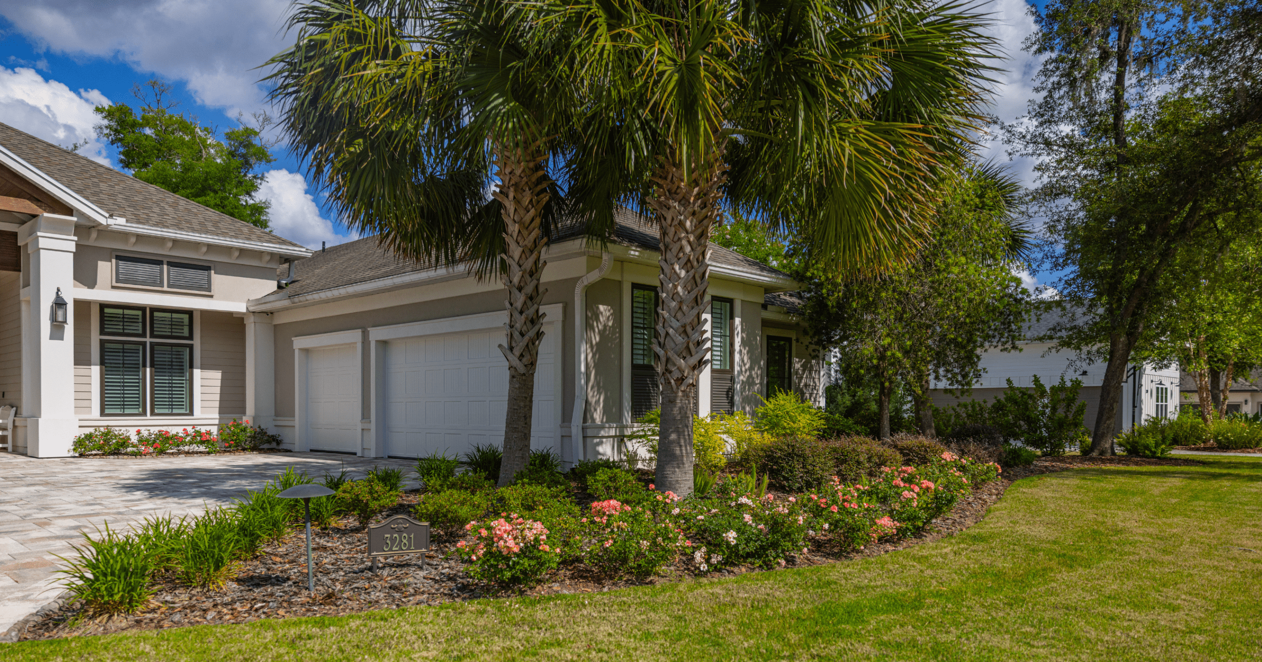 Palm-lined suburban home with landscaped garden and double garage