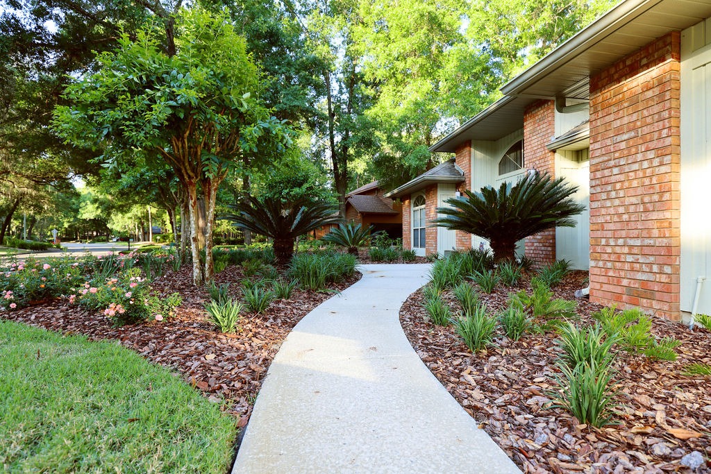 Curved walkway beside landscaped brick suburban home