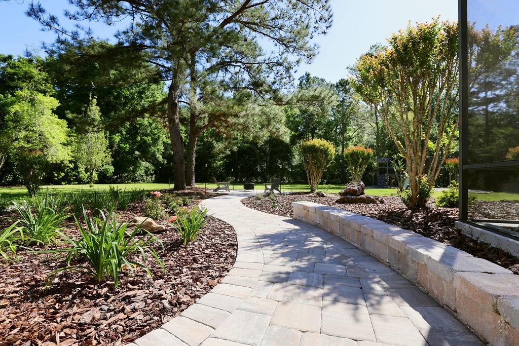 Curving stone path through landscaped garden beside screened porch