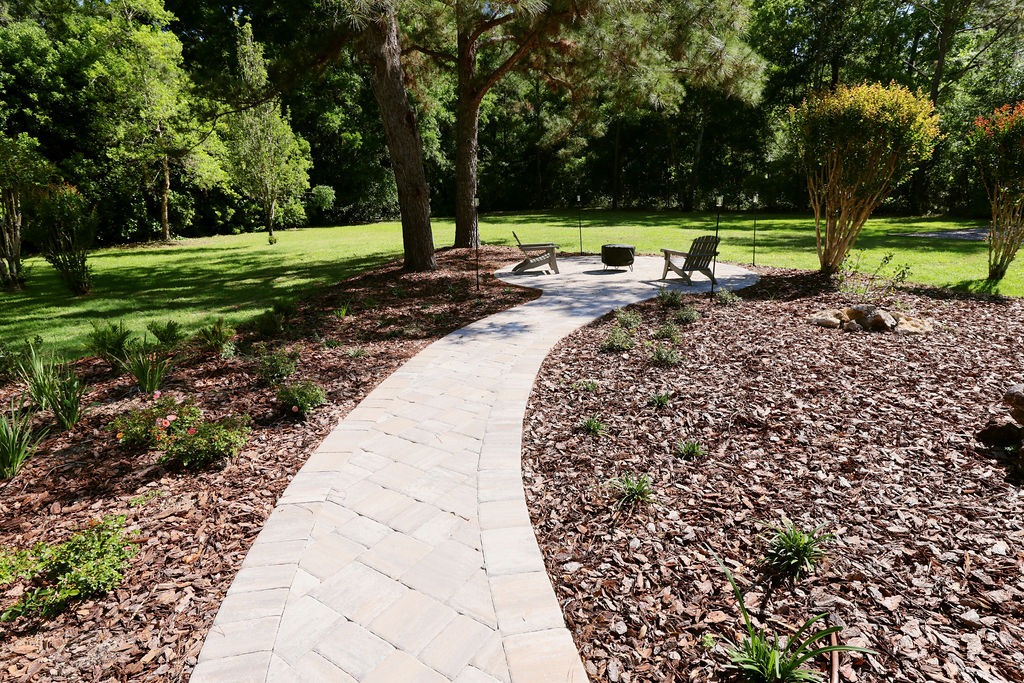 Curved stone garden path leading to shaded seating area