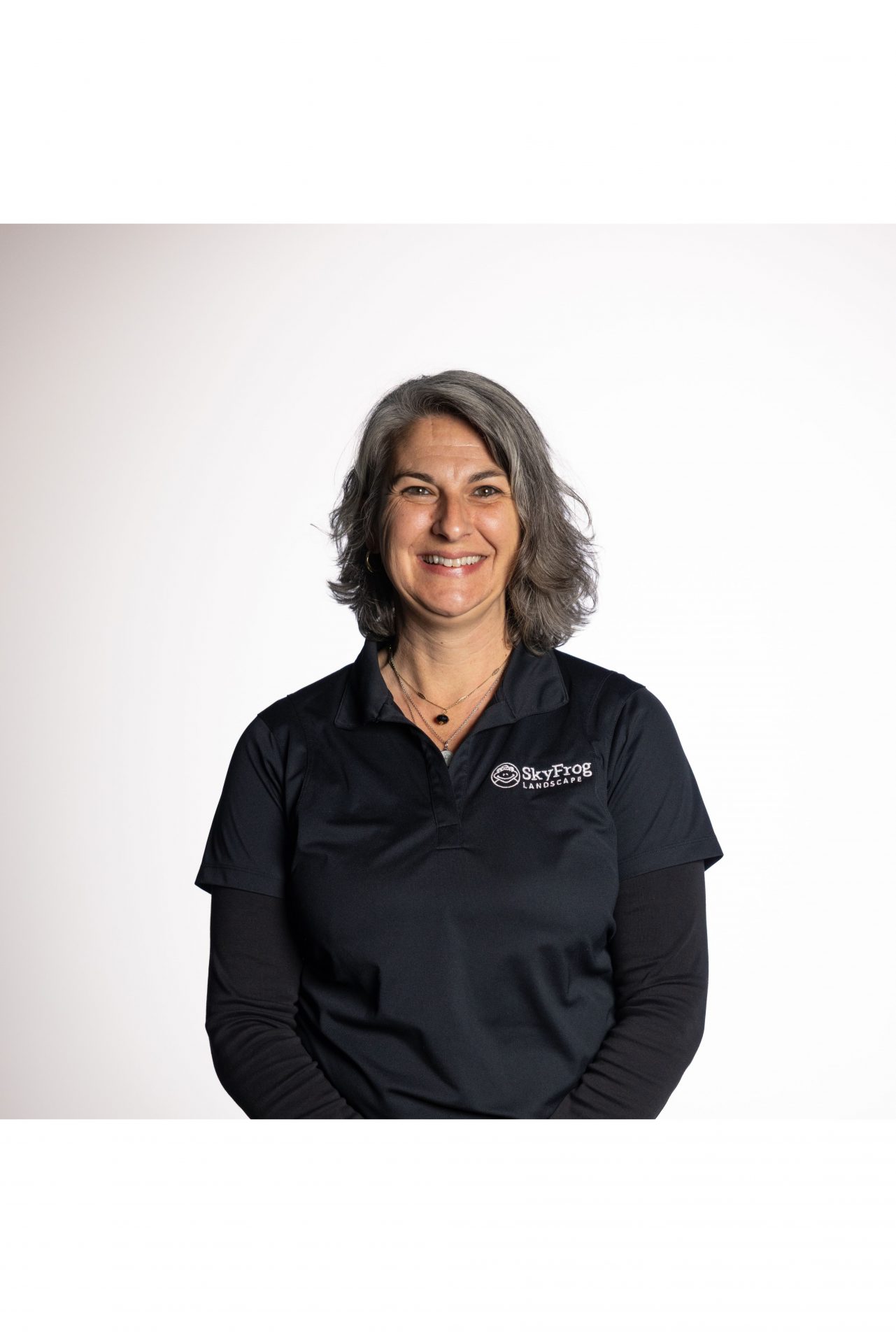 Smiling SkyFrog Landscape employee in black company polo