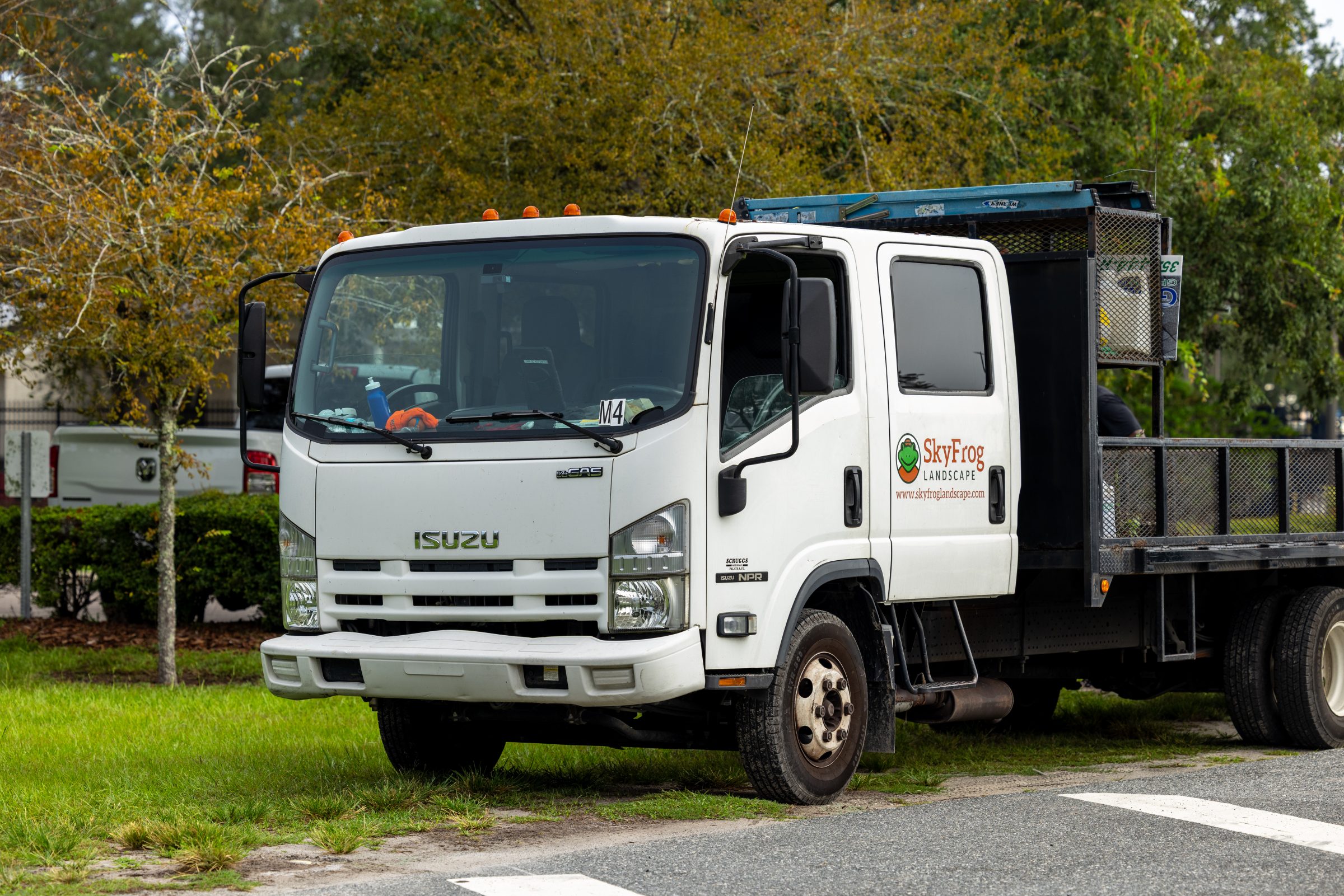SkyFrog Landscape truck parked beside grass and trees