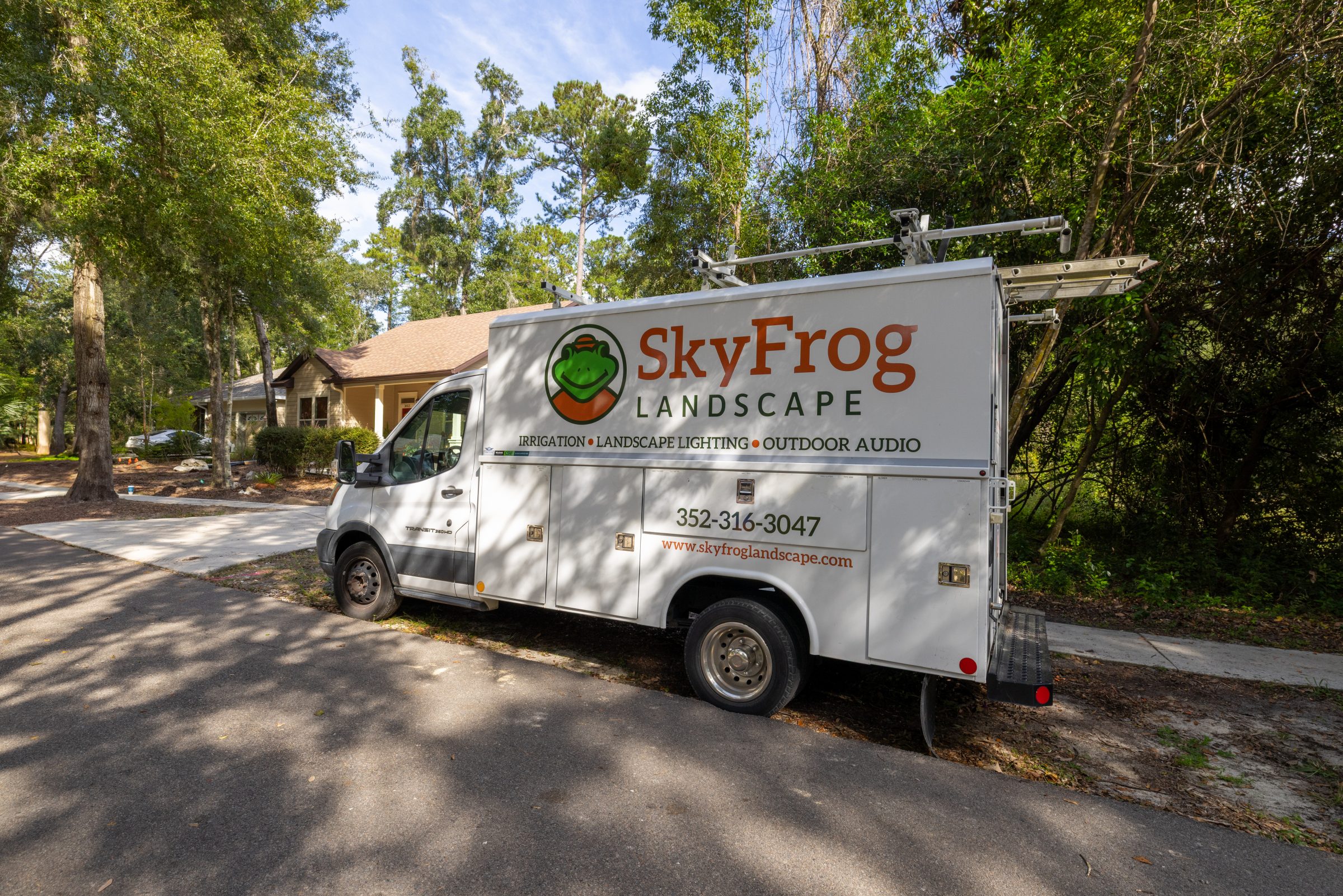 SkyFrog Landscape service truck parked beside tree-lined home