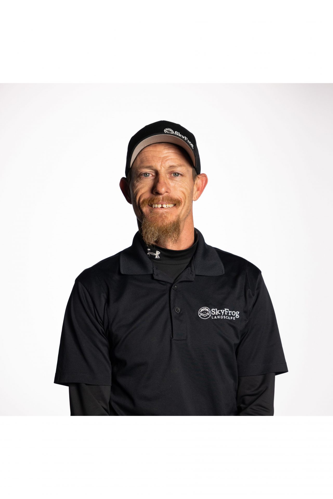 Smiling SkyFrog Landscape employee in black uniform and cap