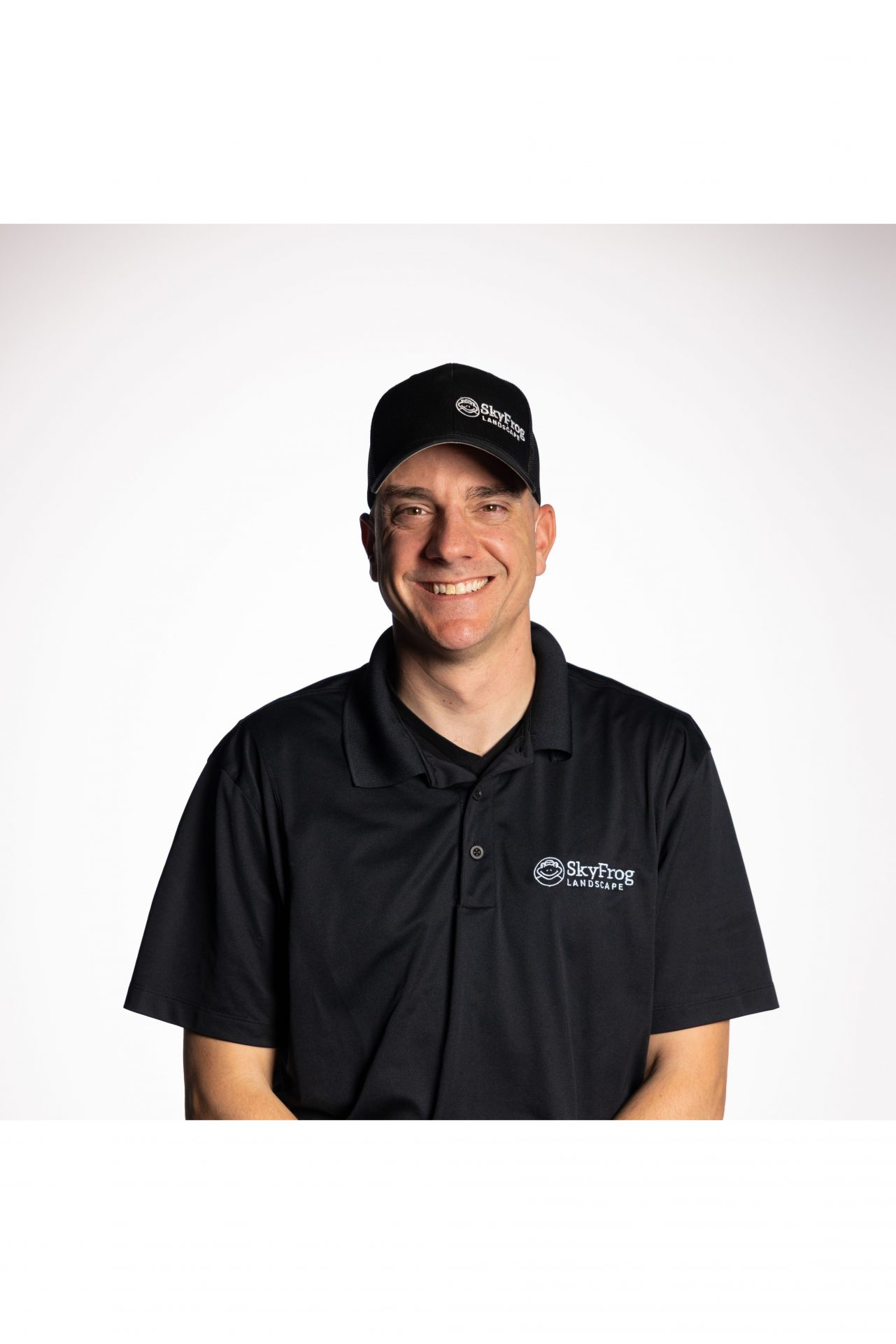 Smiling SkyFrog Landscape employee in black uniform
